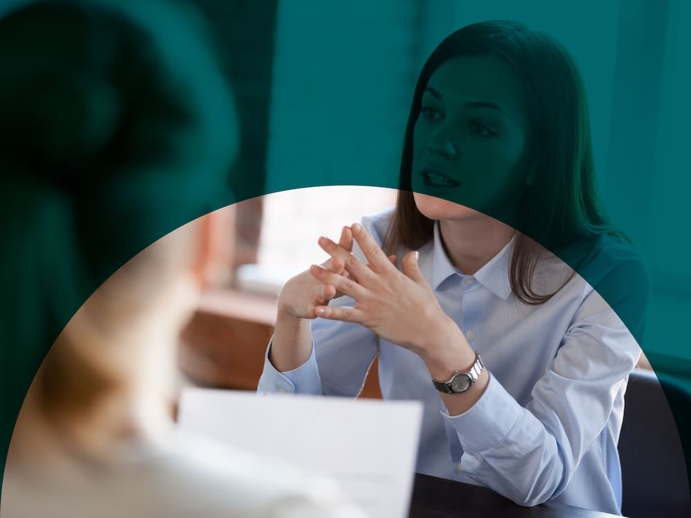 Two people sit opposite each other at a table during executive coaching